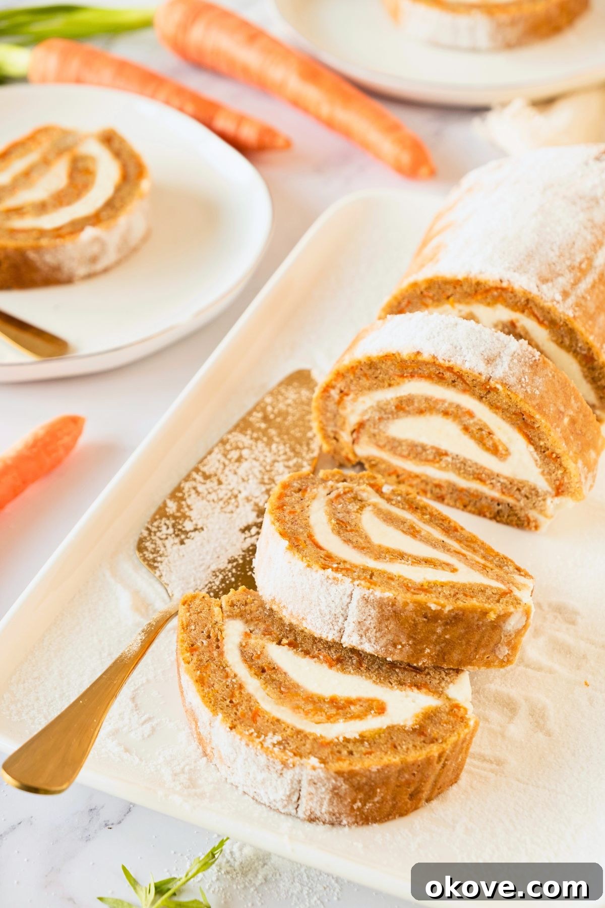 Spiced Carrot Roulade 8 Beautifully sliced carrot cake roll served on a white rectangular plate, garnished with powdered sugar.