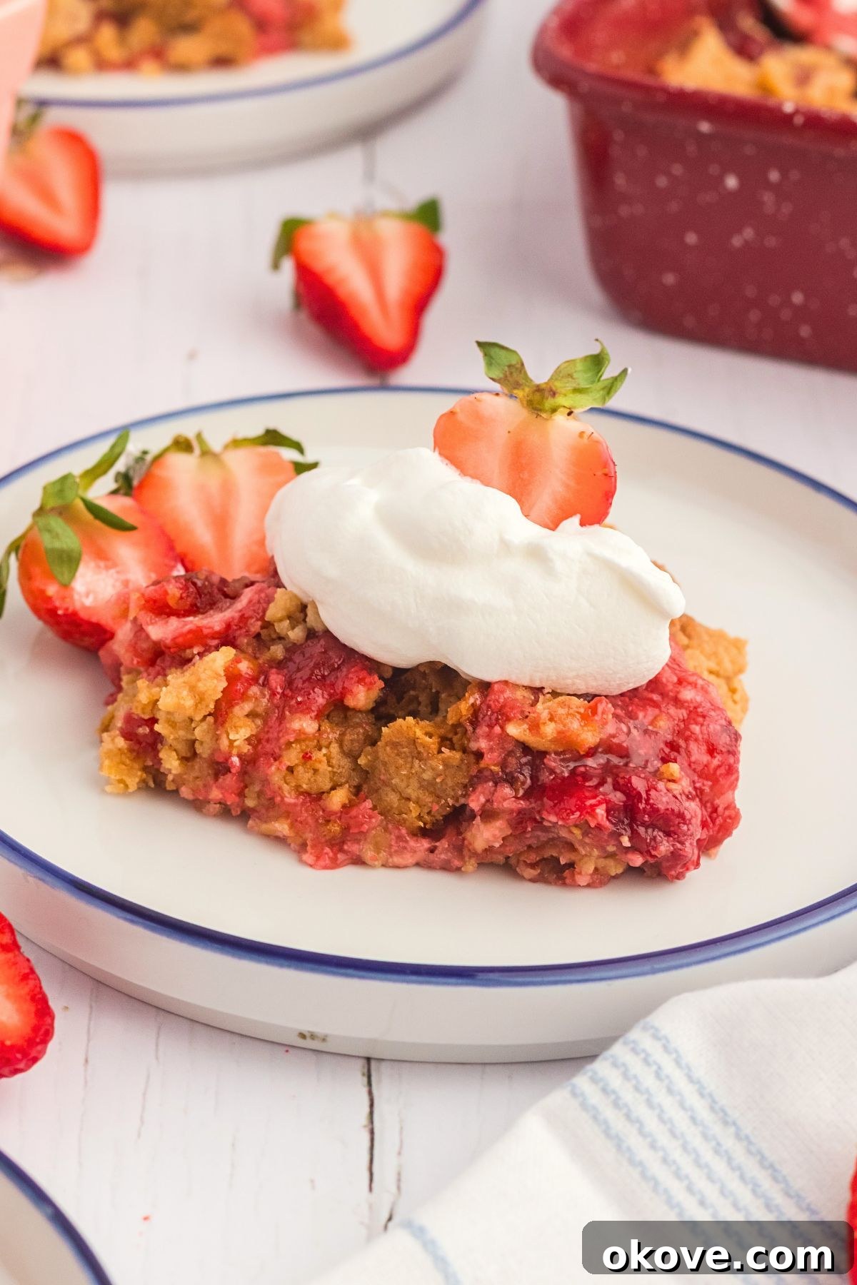 Effortless Strawberry Delight 2 Golden cake crumble on luscious strawberry pie filling, served on a white plate, ready to be enjoyed.