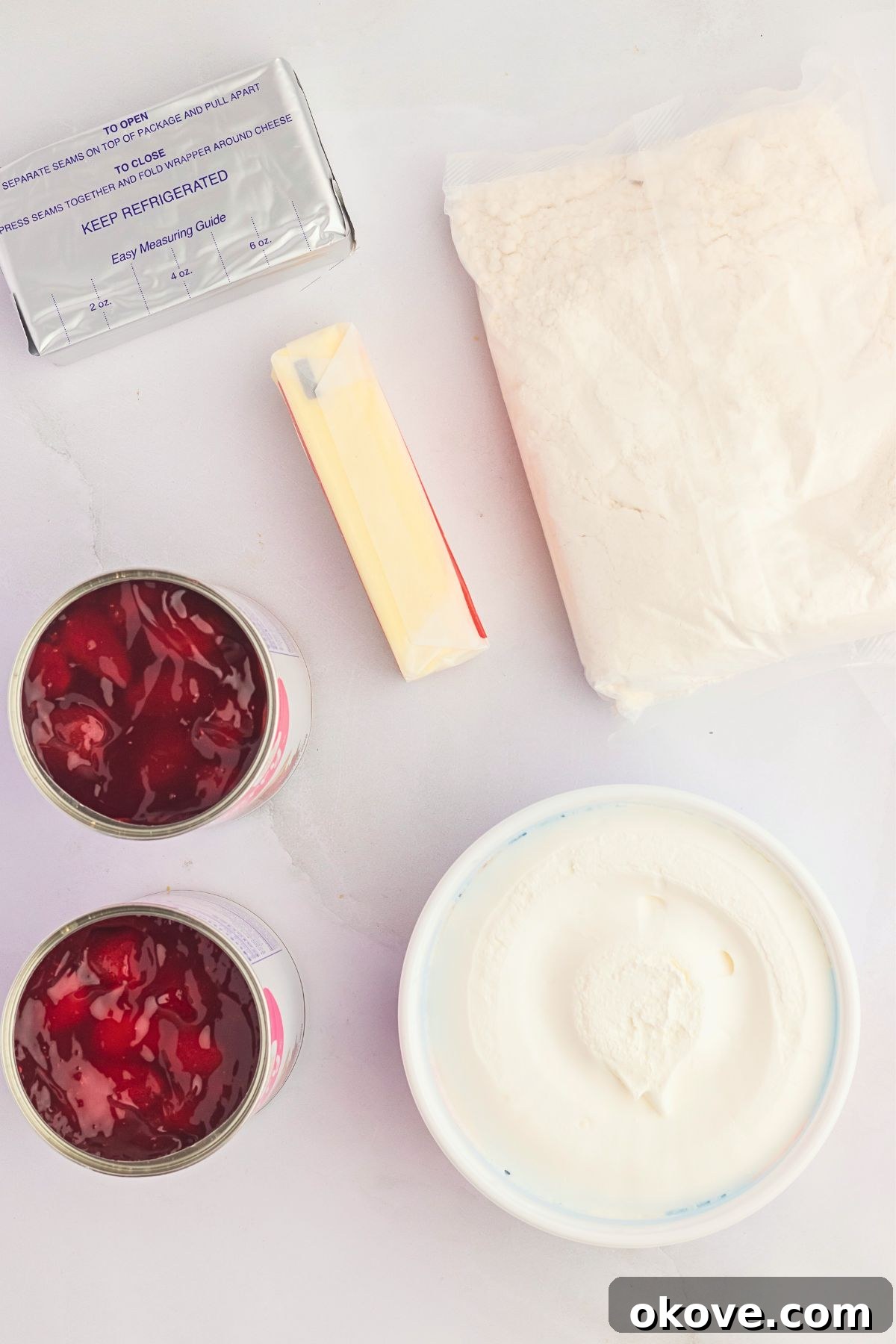 Effortless Strawberry Delight 3 Essential ingredients for making strawberry dump cake, neatly arranged on a white marble table.