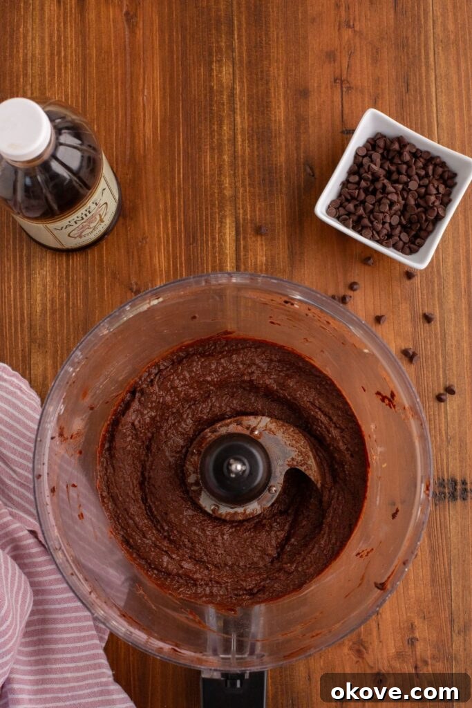 Decadent Chocolate Hummus 5 Smooth and creamy chocolate hummus perfectly blended in the food processor bowl, ready to be transferred.