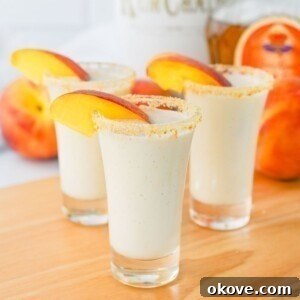 Small shot glasses filled with drinks, then garnished with peach slices.