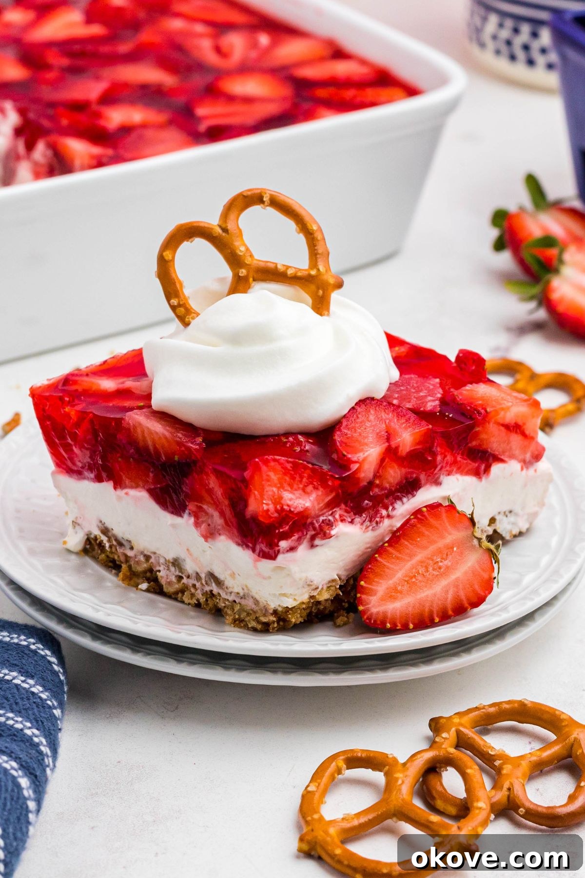 Strawberry Pretzel Dream 2 Layers of strawberry jello, pretzel crust and cream cheese filling, on a black plate.
