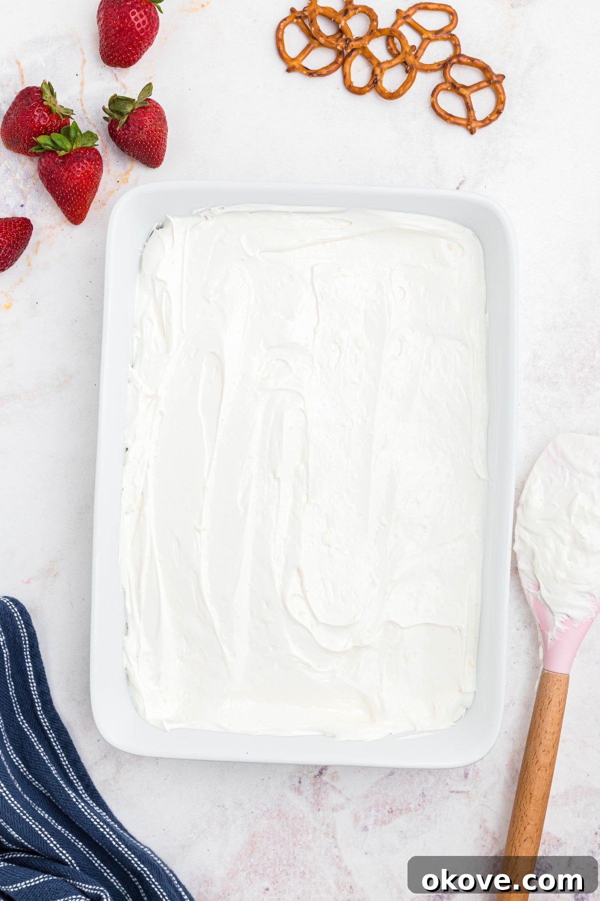 Strawberry Pretzel Dream 9 Whipped topping spread over crust in a 9x13 baking dish.