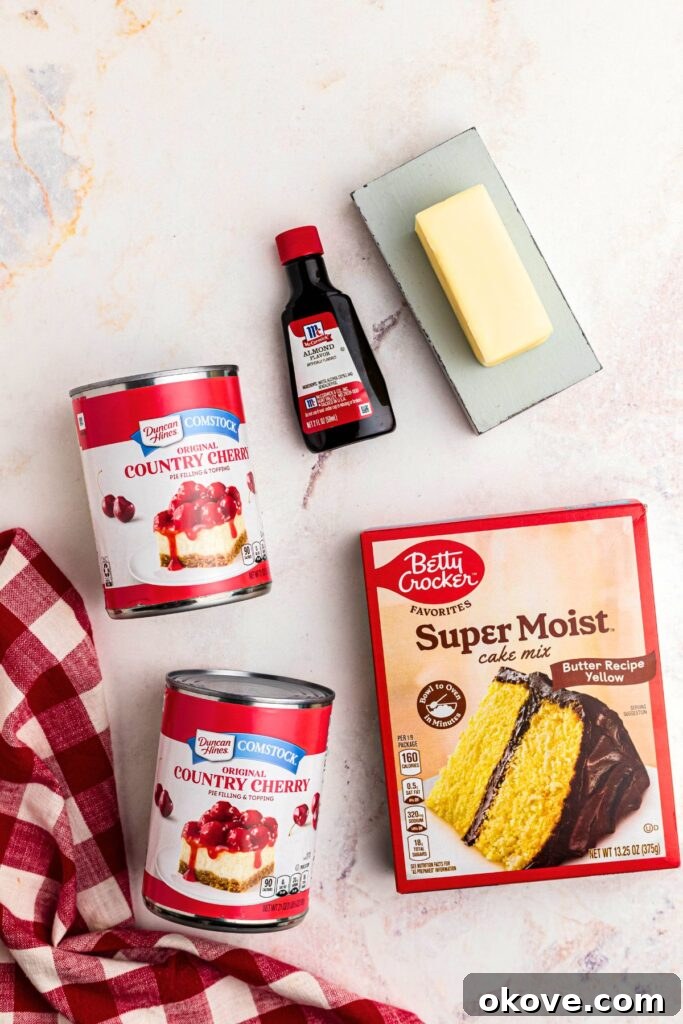 Ingredients needed to make cherry dump cake on a marble table.
