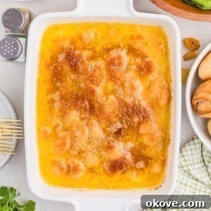 Baked, cheesy shrimp scampi in a white baking dish, ready to be served.