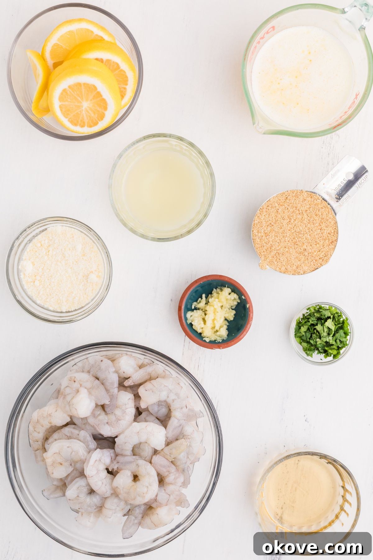 All the necessary ingredients for shrimp scampi meticulously measured into small, elegant dishes, arranged on a beautiful marble tabletop.