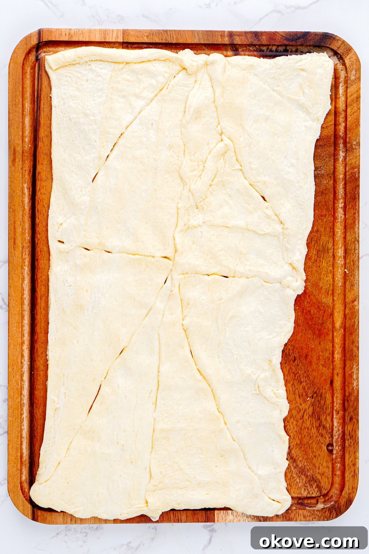 Crescent dough unrolled on a baking sheet.