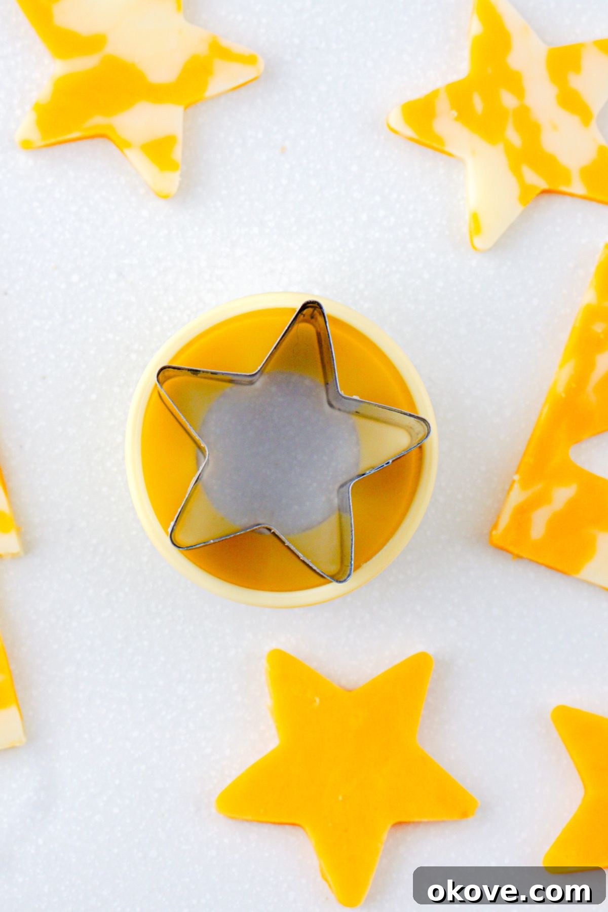 slices of cheese being cut with star cookie cutter.