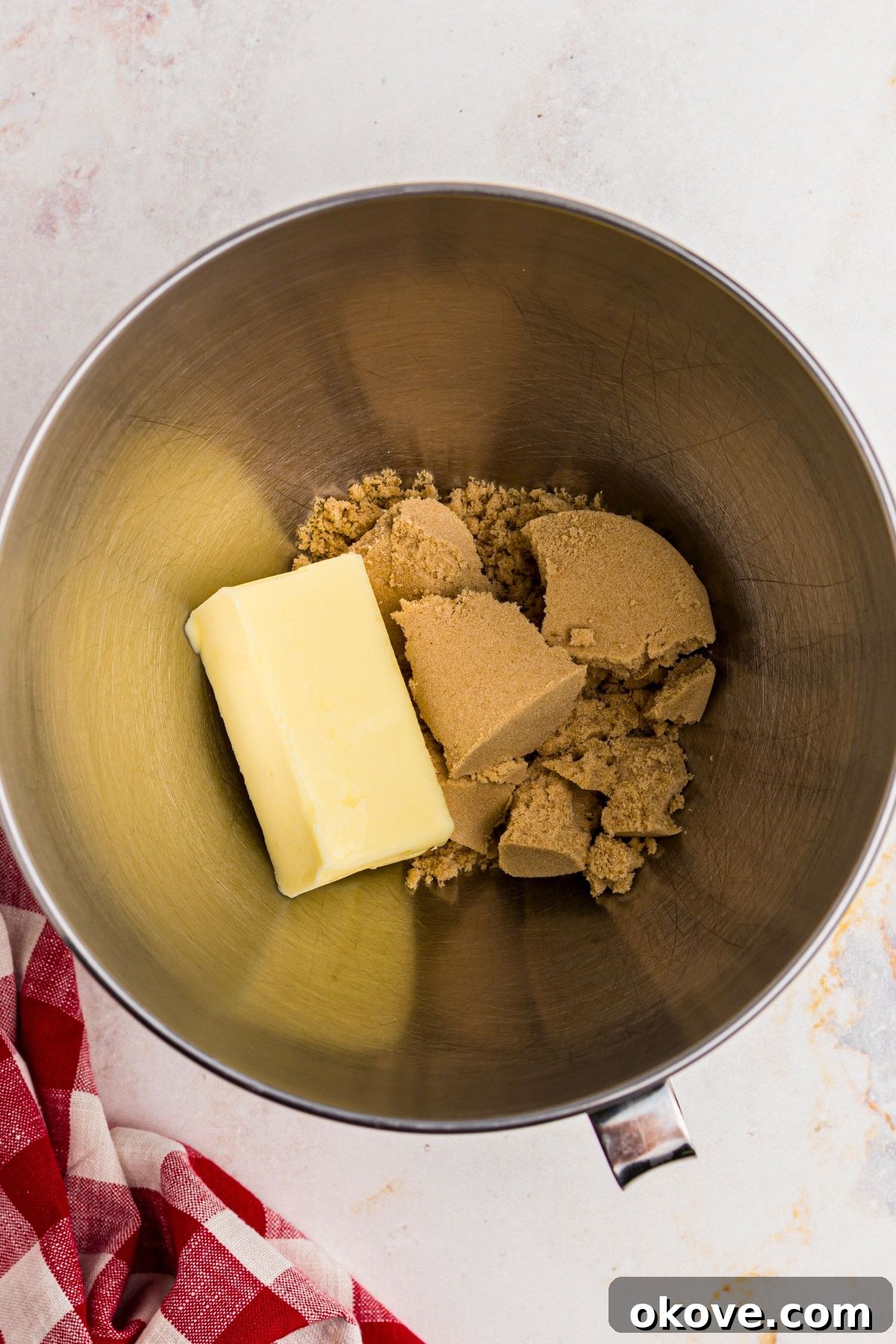 Festive Gingerbread Delights 5 Butter and brown sugar in a silver mixing bowl before mixing together.