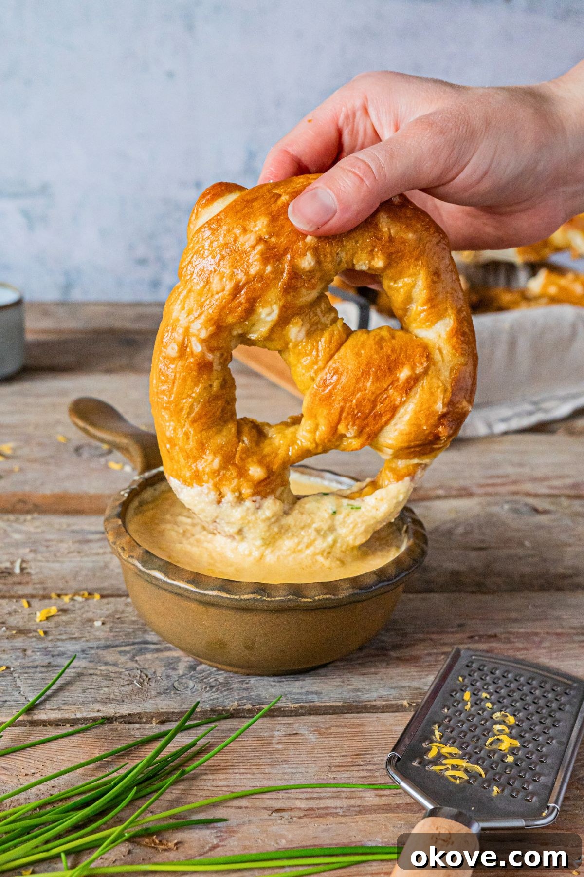 Pillowy Soft Pretzels 14 Soft golden pretzel being dipped into melted beer cheese.
