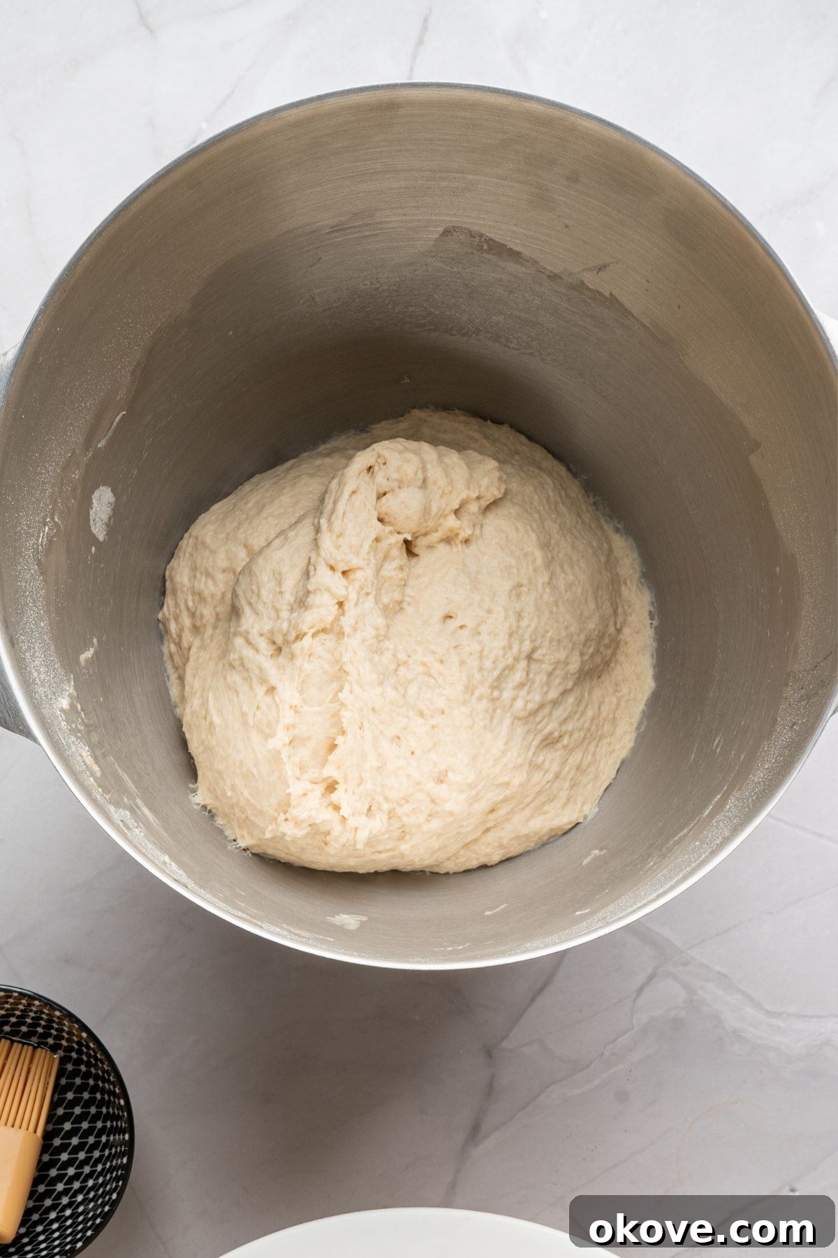 Pillowy Soft Pretzels 5 Bread dough in a silver mixing bowl, waiting for dough to rise.