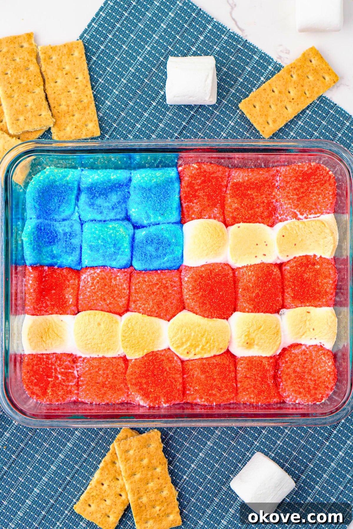 Red, White, and Gooey S'mores Dip 2 Red, white, and blue marshmallows arranged over melted chocolate in a clear baking dish, with graham crackers ready for dipping on the side.