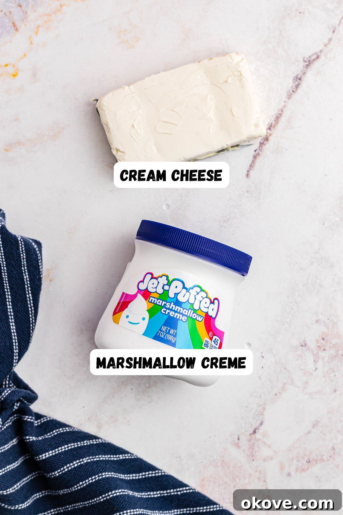 Sweet and Creamy Fruit Dip 3 Two key ingredients for the fruit dip, a tub of creamy marshmallow creme and a block of cream cheese, are neatly placed on a pristine marble countertop, ready for mixing.