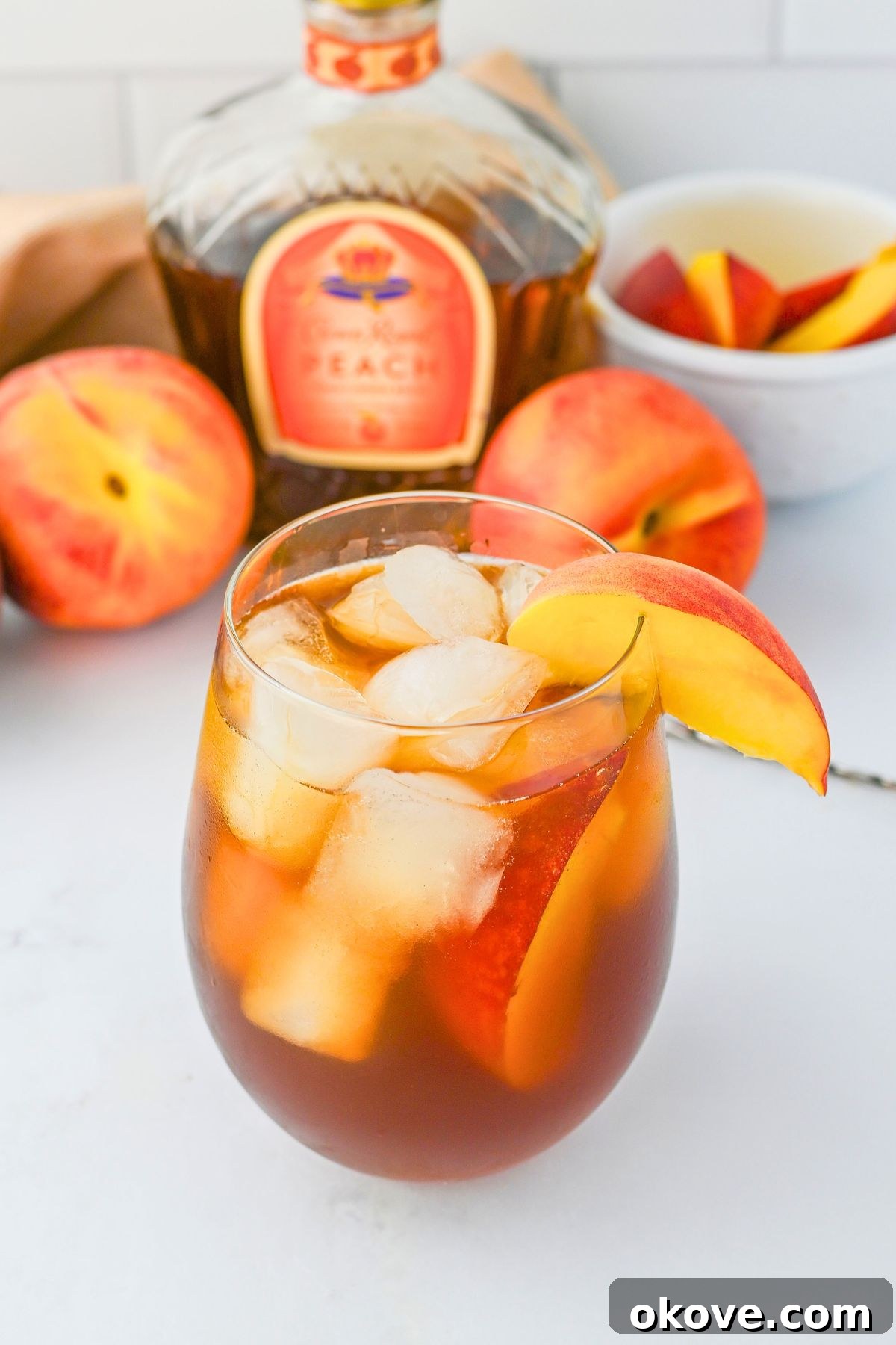 Imperial Peach Nectar 6 A refreshing Royal Peach Tea cocktail, garnished with a peach slice, gleaming with condensation and inviting sips.
