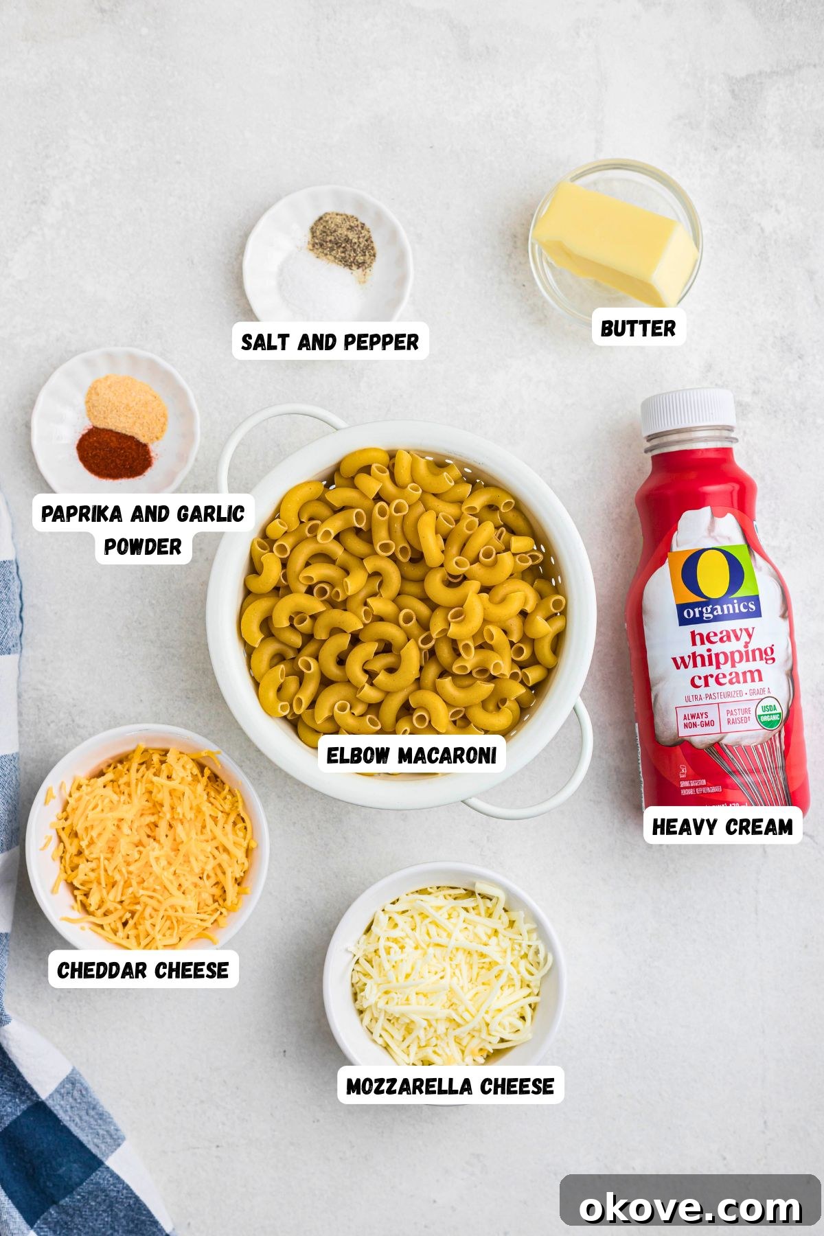 Golden Baked Mac 3 Ingredients needed to make baked mac and cheese in small white bowls on a marble table top.