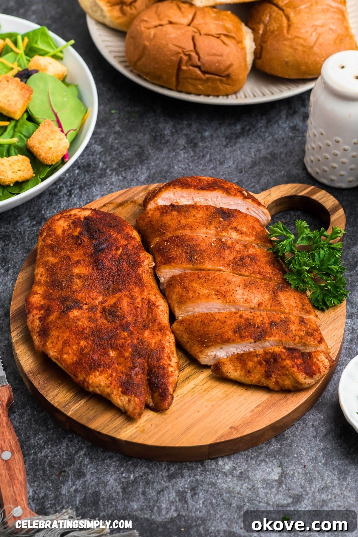 Perfectly seasoned smoked chicken breasts resting on a wooden cutting board, ready for slicing.