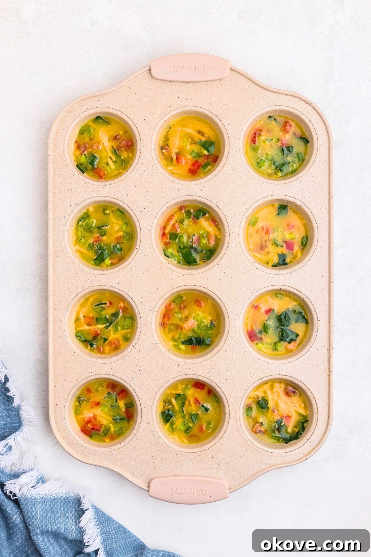 Egg mixture divided into muffin pan before baking.