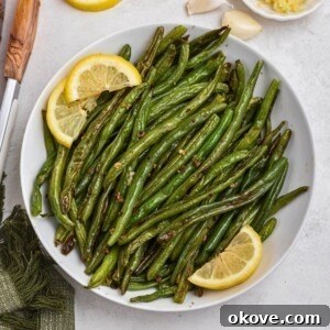 A close-up of perfectly roasted green beans in a bowl, ready to be served.