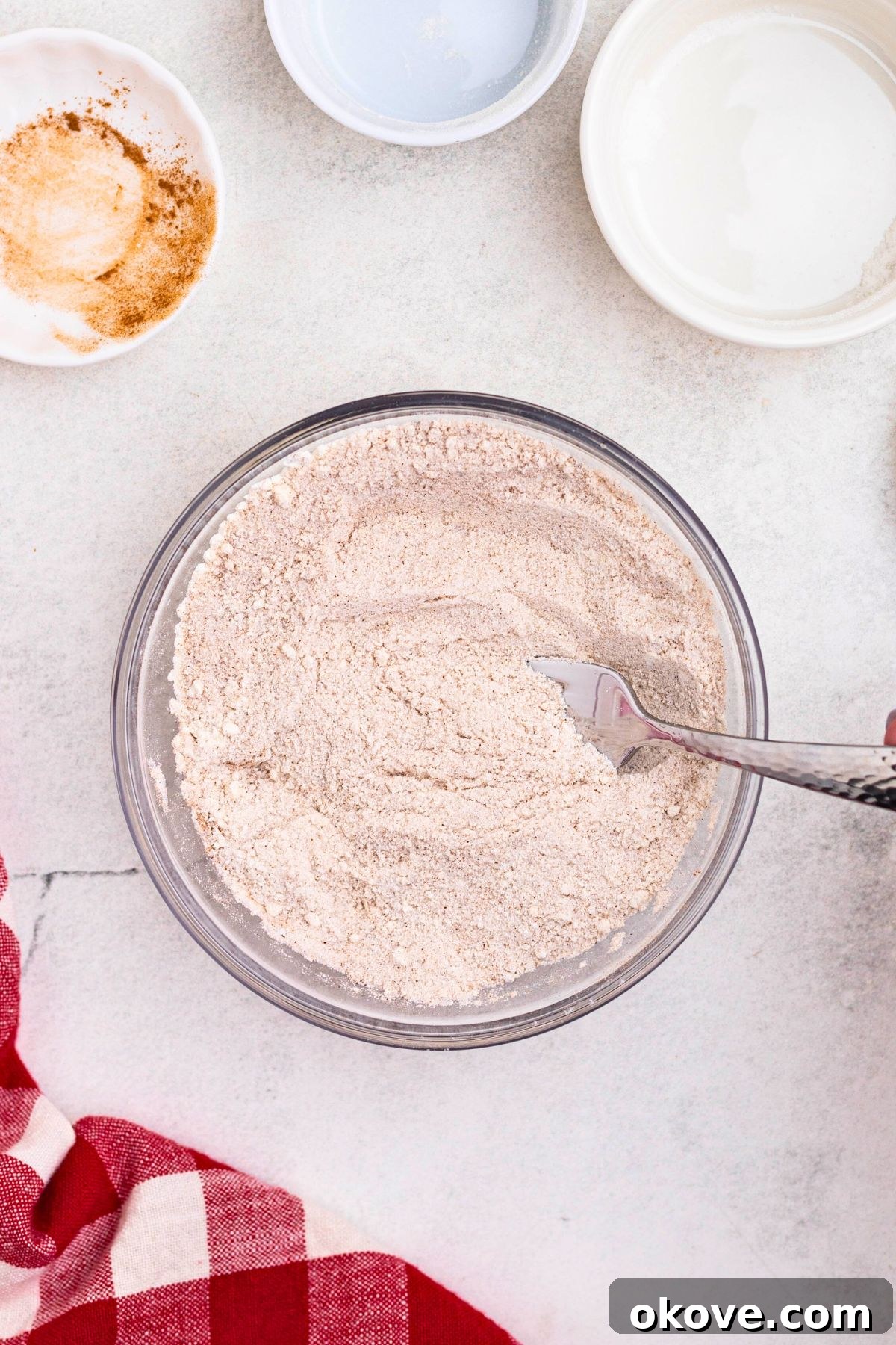 Flour, sugar, cinnamon, and nutmeg, mixed together in a medium bowl. 