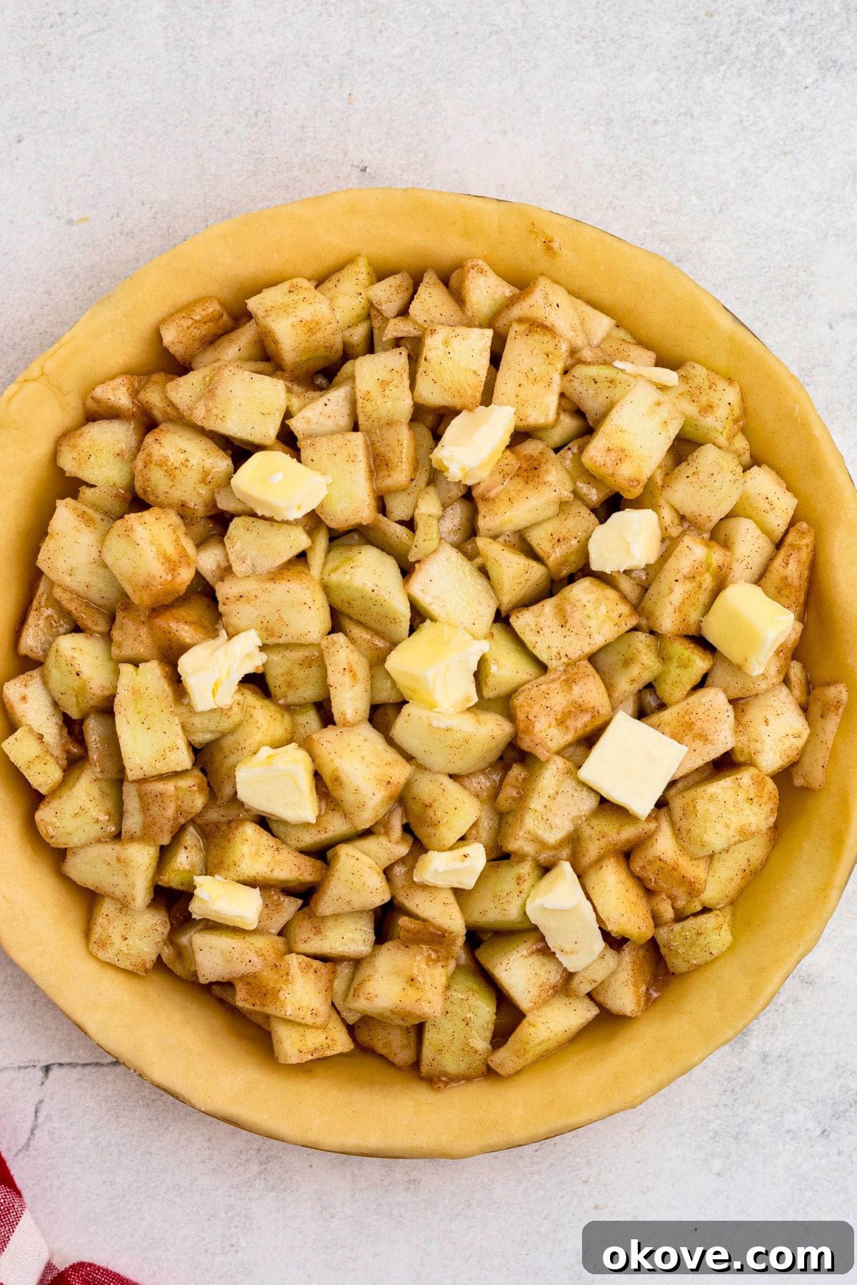 Bottom pie crust filled with apple pieces tossed in flour and seasonings, and cubes of butter. 