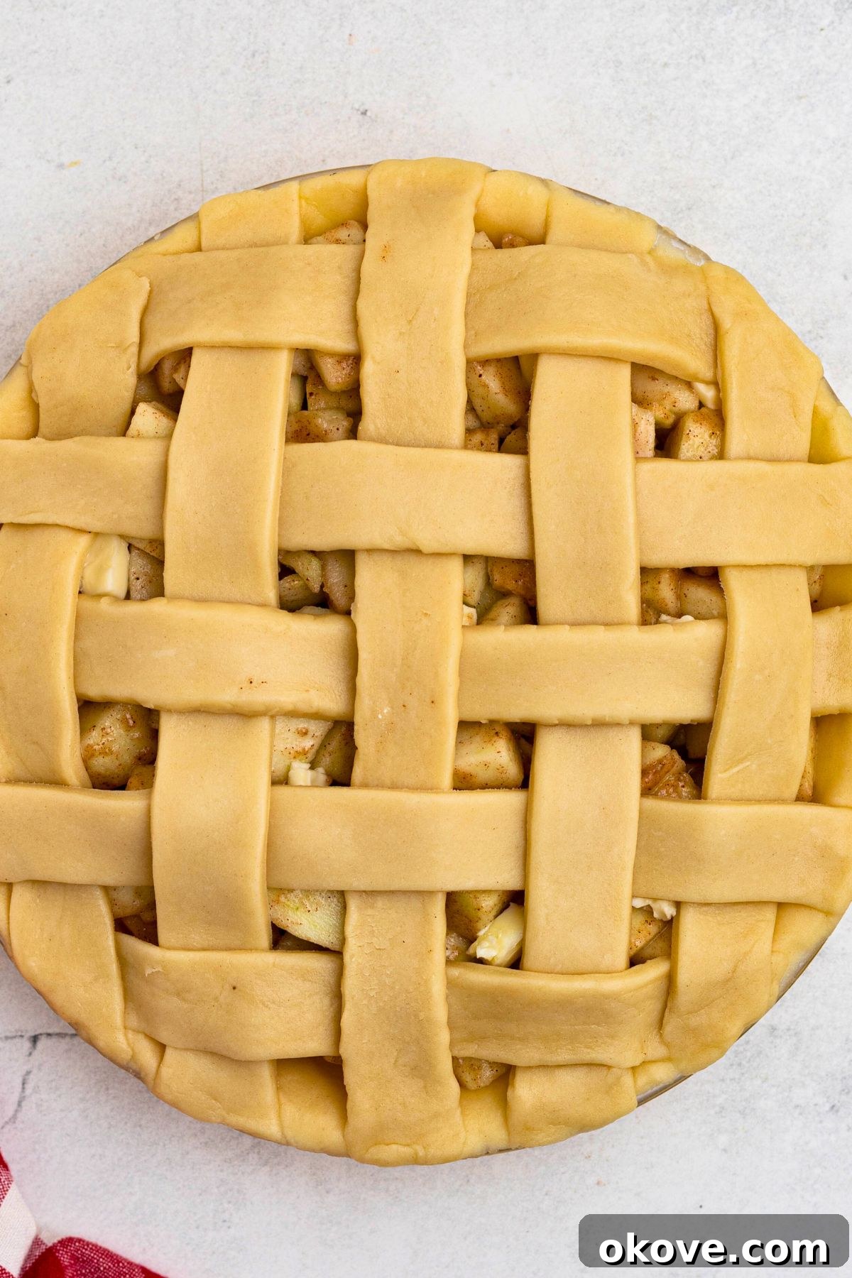 Unbaked apple pie with criss cross lattice crust on top. 