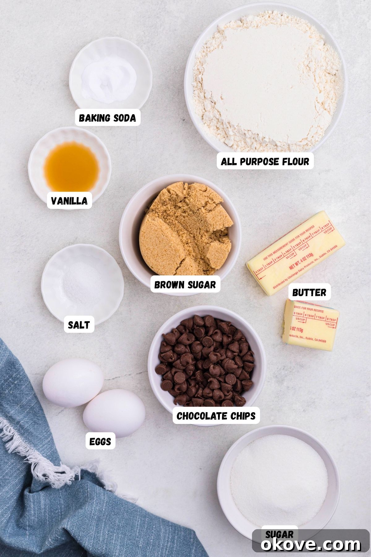 Ultimate Chocolate Chip Bars 3 Ingredients needed to make chocolate chip cookie bars measured into small bowls on a white marble table.