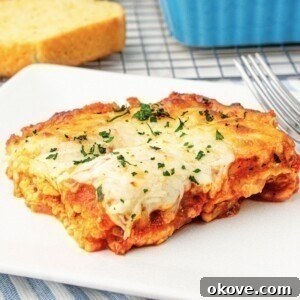 Cheese slice of ravioli lasagna on a square white plate.