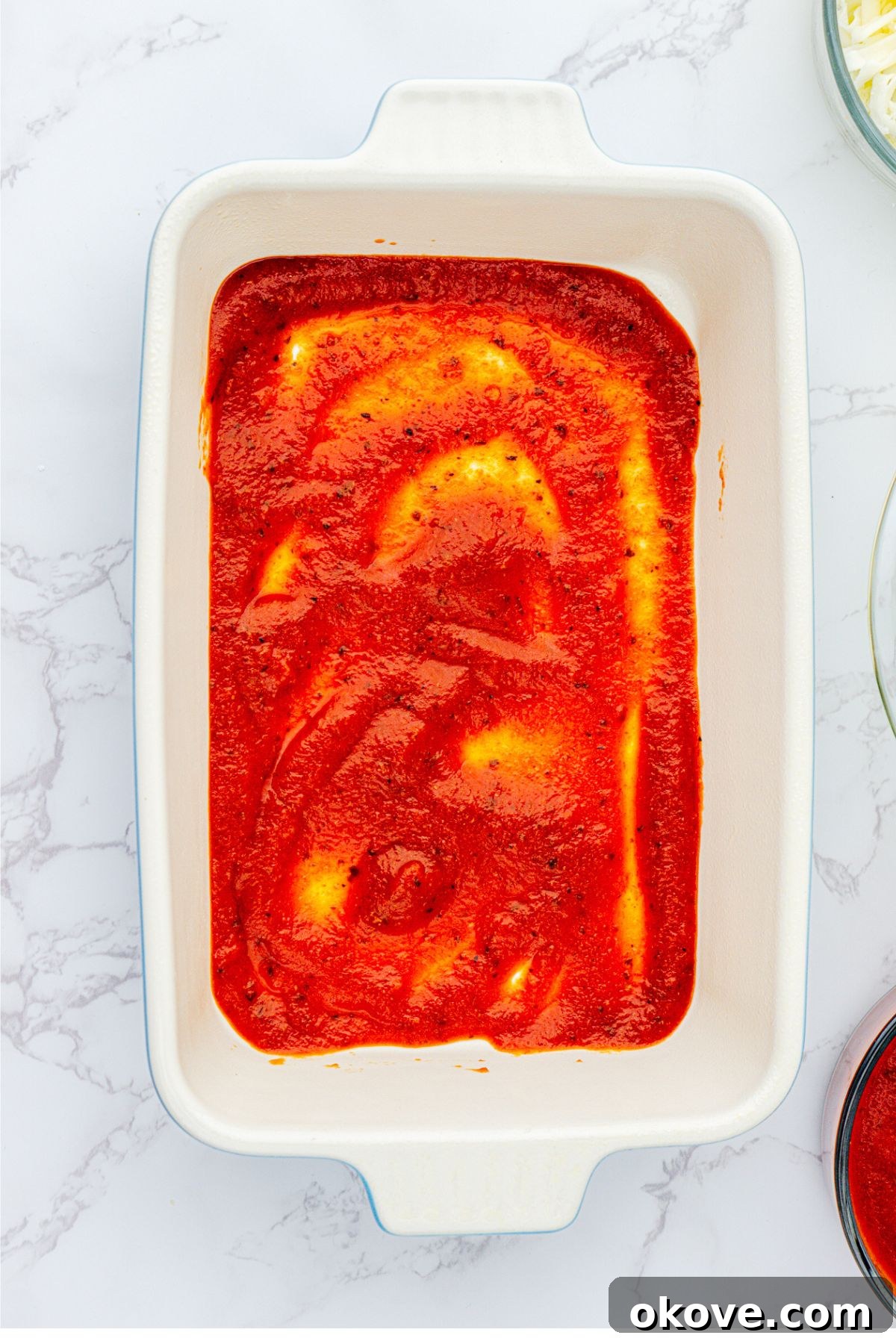 Stacked Ravioli Lasagna 4 White rectangle casserole dish with red sauce.