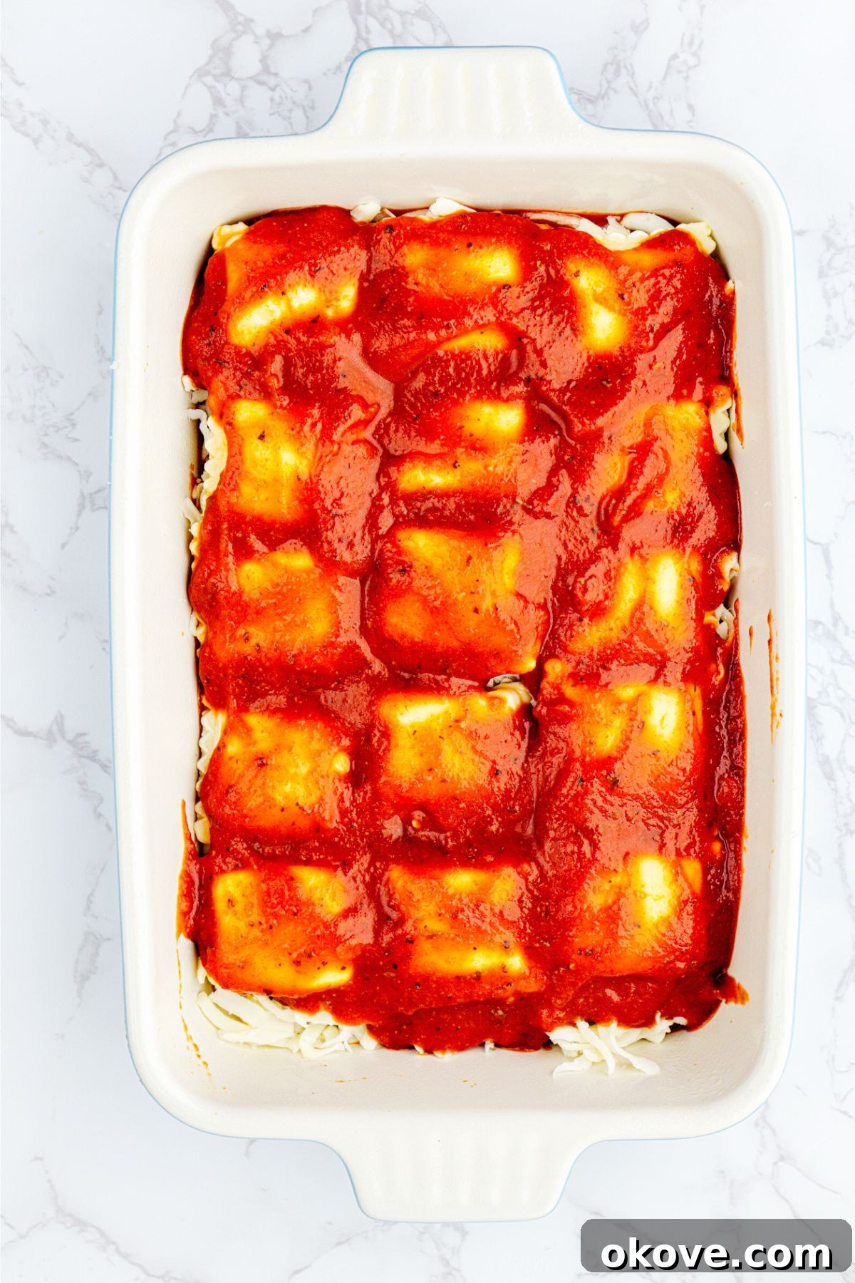 Stacked Ravioli Lasagna 6 Layers of ravioli, sauce, and cheese, in a white rectangle dish.