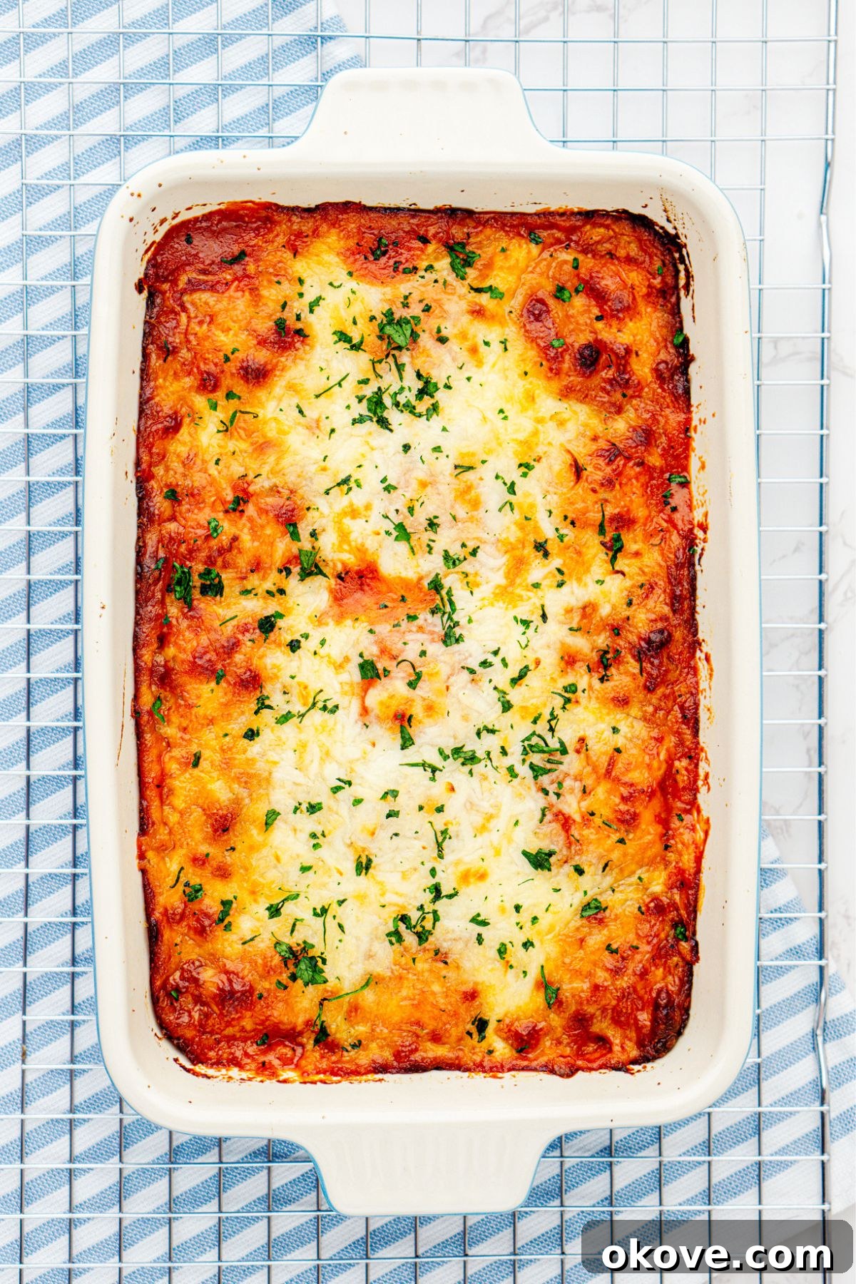 Stacked Ravioli Lasagna 7 baked casserole dish filled with layers of ravioli, cheese, and sauce, after it's been baked.
