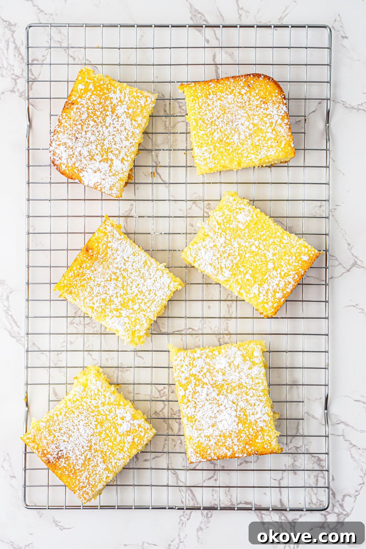 Effortless Two-Ingredient Lemon Bars 7 Bright yellow lemon bars baked and cooling on a wire rack. Cooling ensures perfect texture.