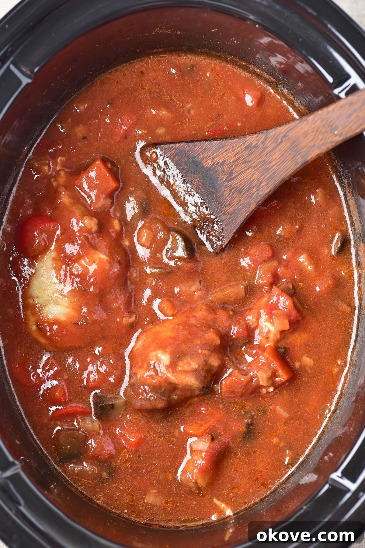 Deliciously Simple Slow Cooker Chicken Cacciatore 7 The finished chicken cacciatore, cooked in the slow cooker, with incredibly tender chicken bathing in a rich, thick red sauce, garnished with herbs, ready to be served.