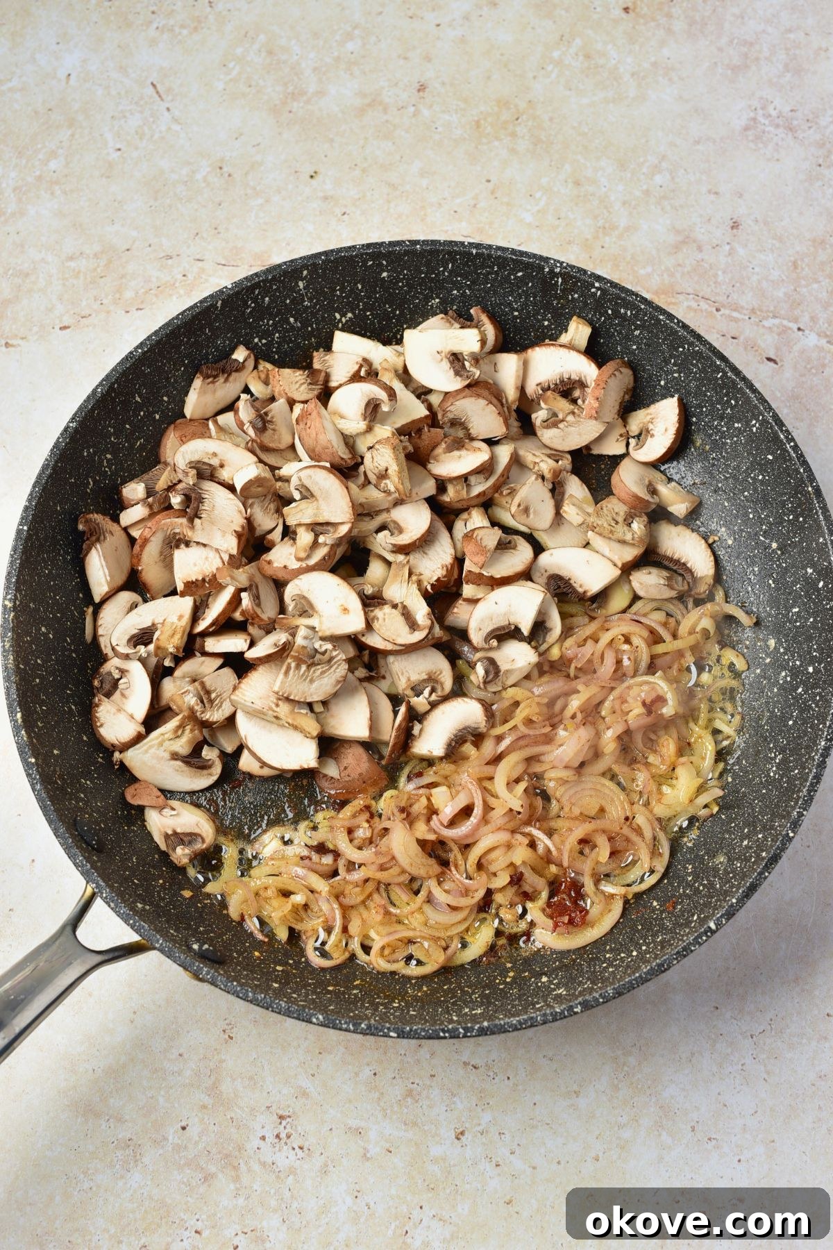 Mushrooms and other ingredients being cooked in a large skillet.