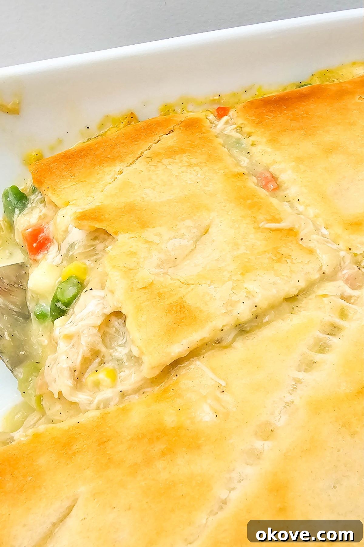 Homestyle Chicken Pot Pie Bake 8 The fully baked chicken pot pie casserole in its dish, boasting a beautifully golden brown, flaky crescent roll crust.