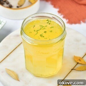 Small jar filled with yellow chicken stock.