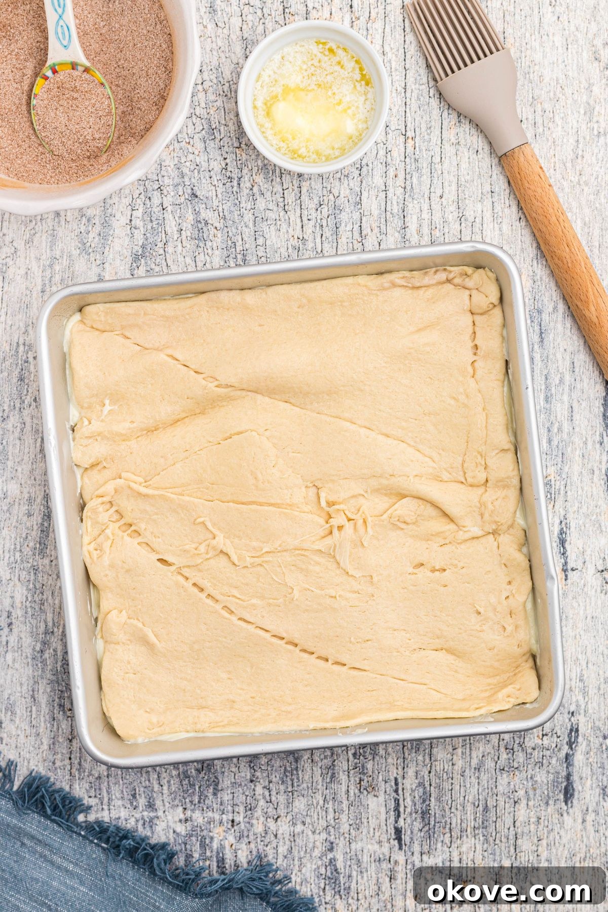 Cinnamon Sugar Crust Cheesecake 8 Crescent roll dough rolled out and topping cheesecake filling.