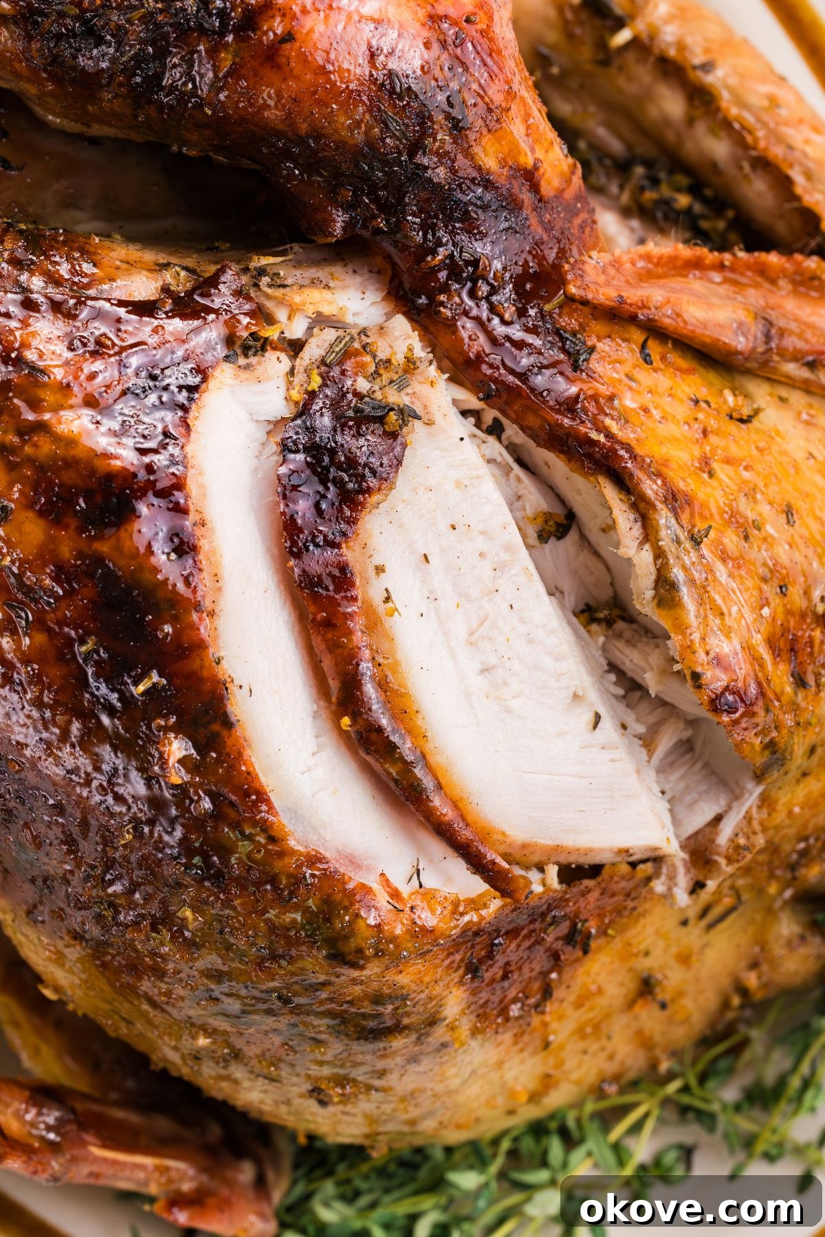 Golden Roasted Turkey Perfection 11 Golden brown juicy turkey being sliced with a knife, on a serving platter.