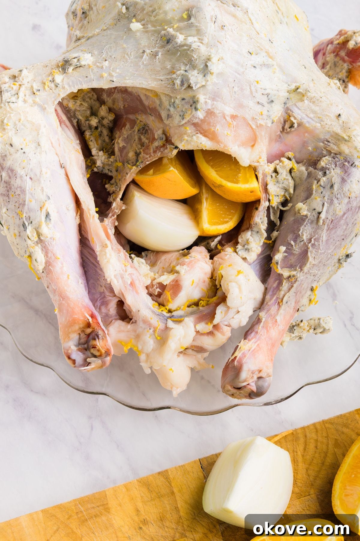 Golden Roasted Turkey Perfection 7 Uncooked whole turkey, seasoned, and stuffed with oranges and onion slices.
