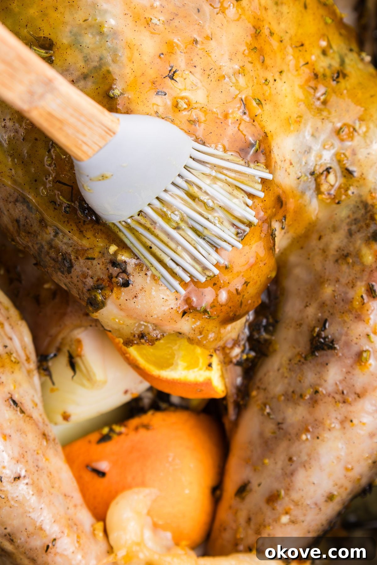 Golden Roasted Turkey Perfection 10 Orange glaze being brushed on a turkey during cooking.