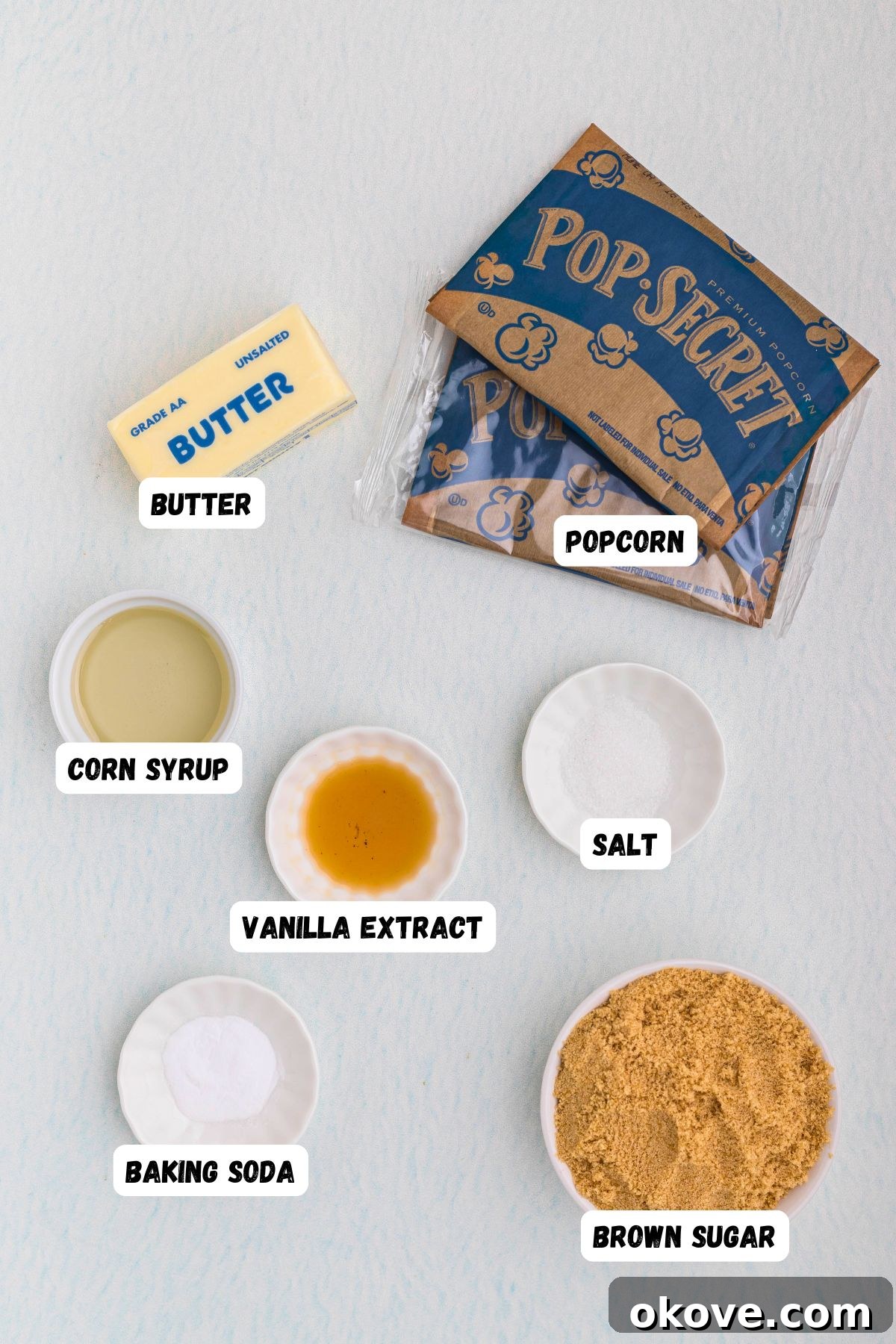 Golden Caramel Crunch 3 Ingredients measured into small bowls and labeled on a marble table.