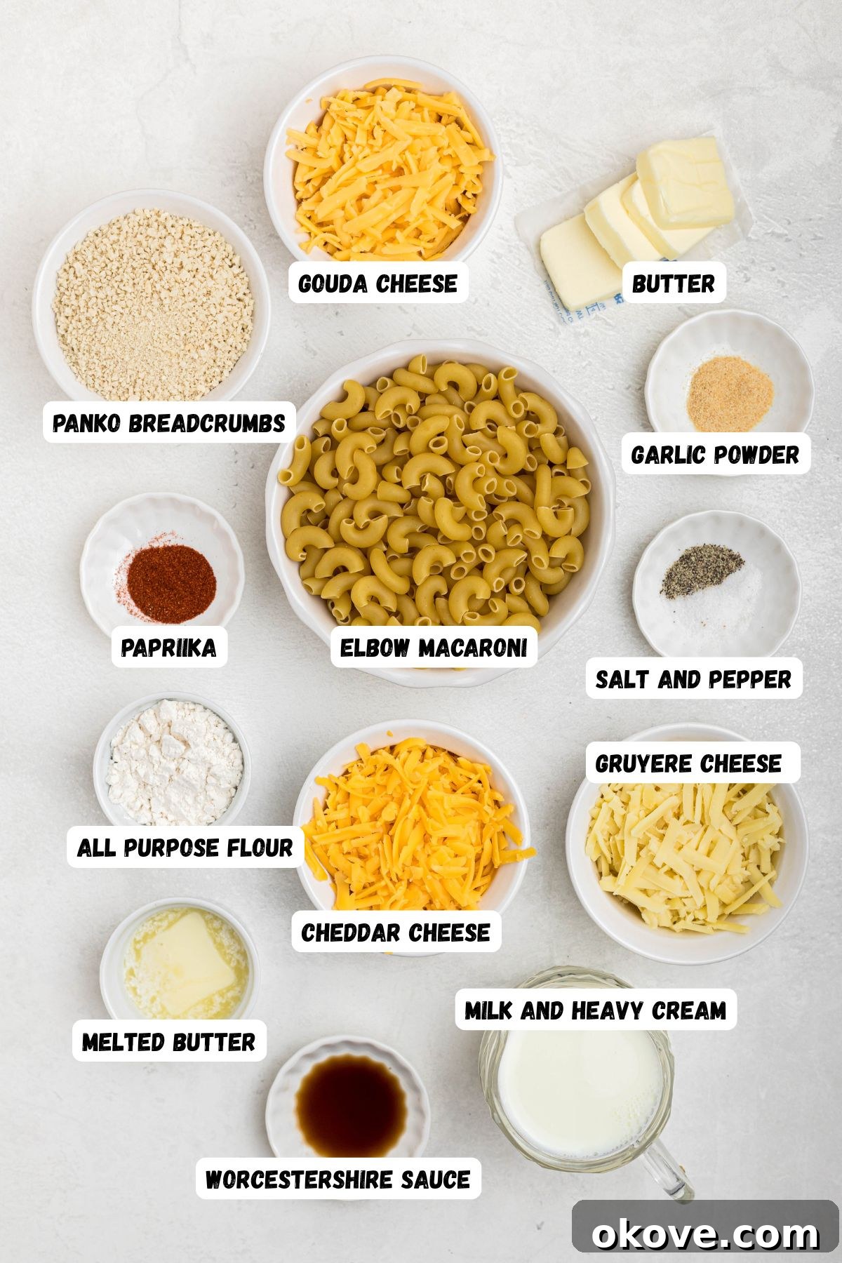 Ultimate Smoked Macaroni and Cheese Bake 3 Ingredients measured into small bowls on a white marble table with labels over each bowl.