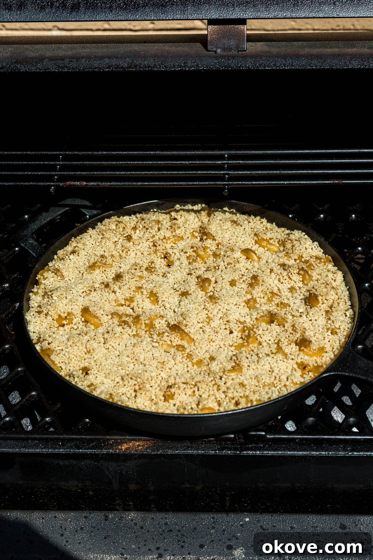 Ultimate Smoked Macaroni and Cheese Bake 9 Cast iron skillet with mac and cheese, in a smoker grill.