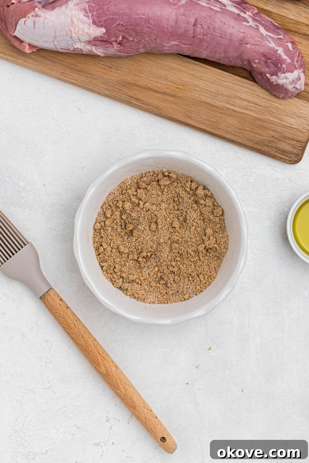 Smoky Pork Tenderloin Perfection 5 Seasonings and brown sugar in a small white bowl, mixed together, on a white marble table, before being added to the pork tenderloins and smoked. This mixture will form a delicious crust.