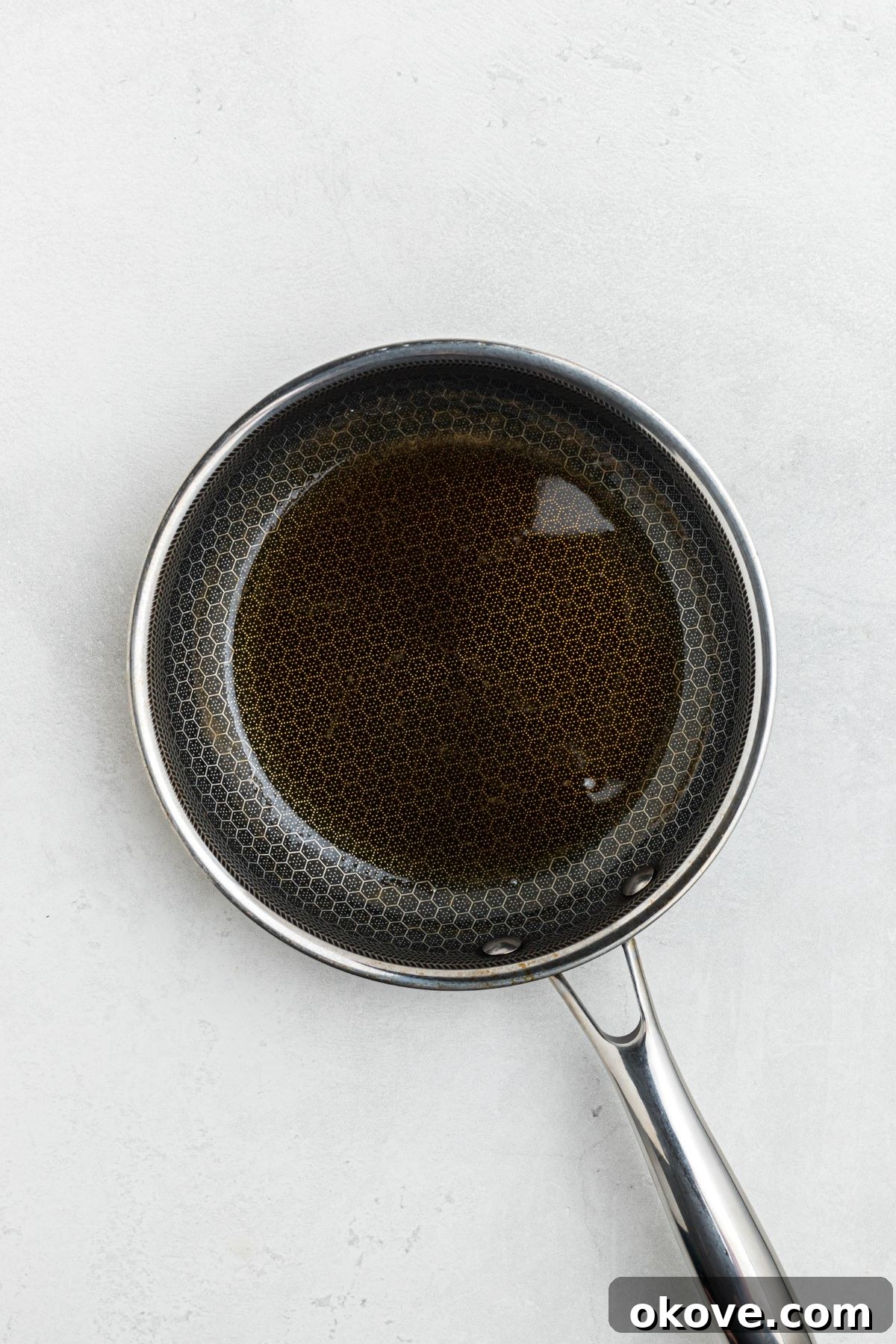Smoky Pork Tenderloin Perfection 7 Small saucepan with honey and apple cider vinegar simmering, creating a warm, slightly thickened glaze ready to be brushed on the smoked pork tenderloin.