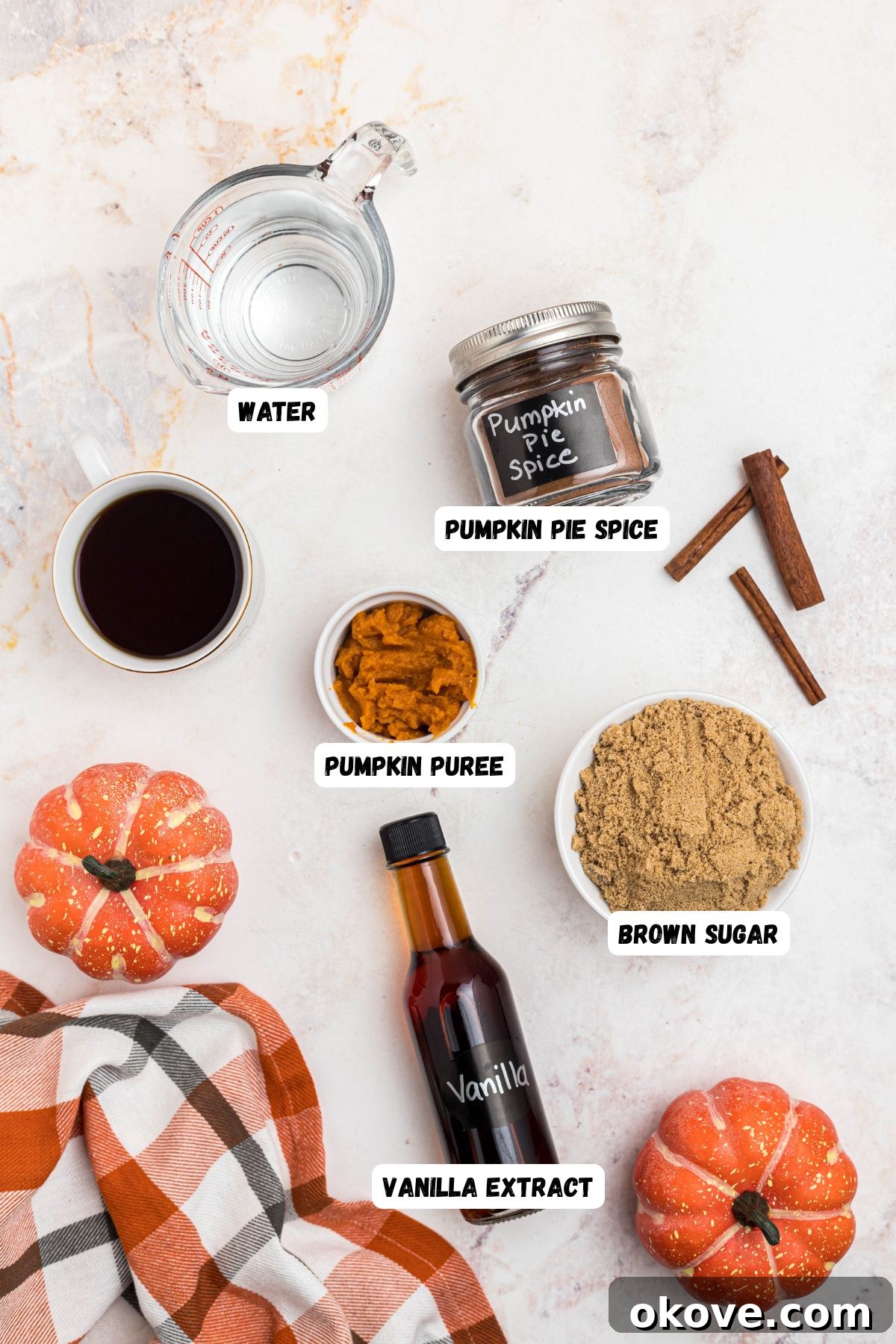 Golden Autumn Elixir 3 Ingredients for pumpkin spice syrup measured in small bowls, then labeled, on a marble table.