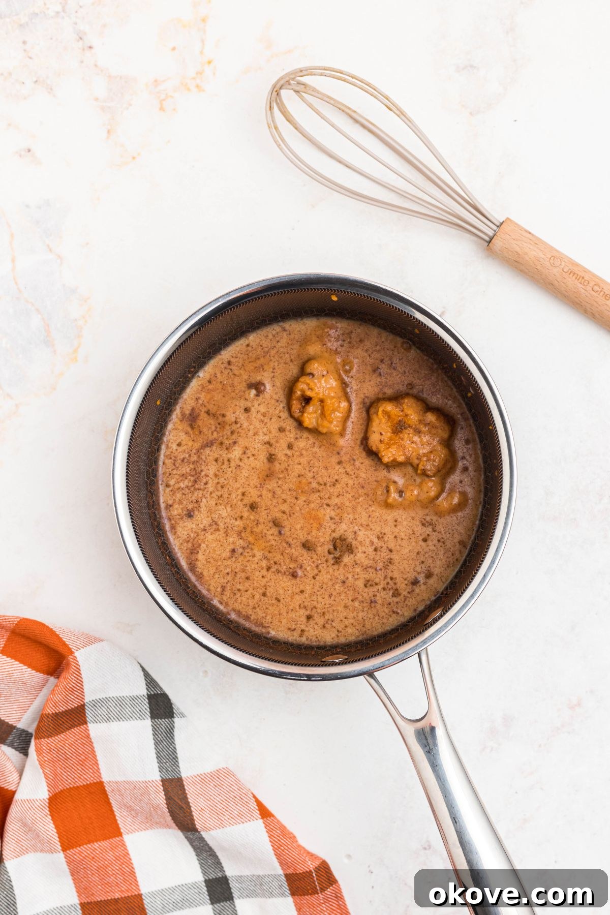 Cozy Pumpkin Spice Brew 4 Milk, pumpkin puree, maple syrup, and pumpkin pie spice combined in a small saucepan, ready to be heated.