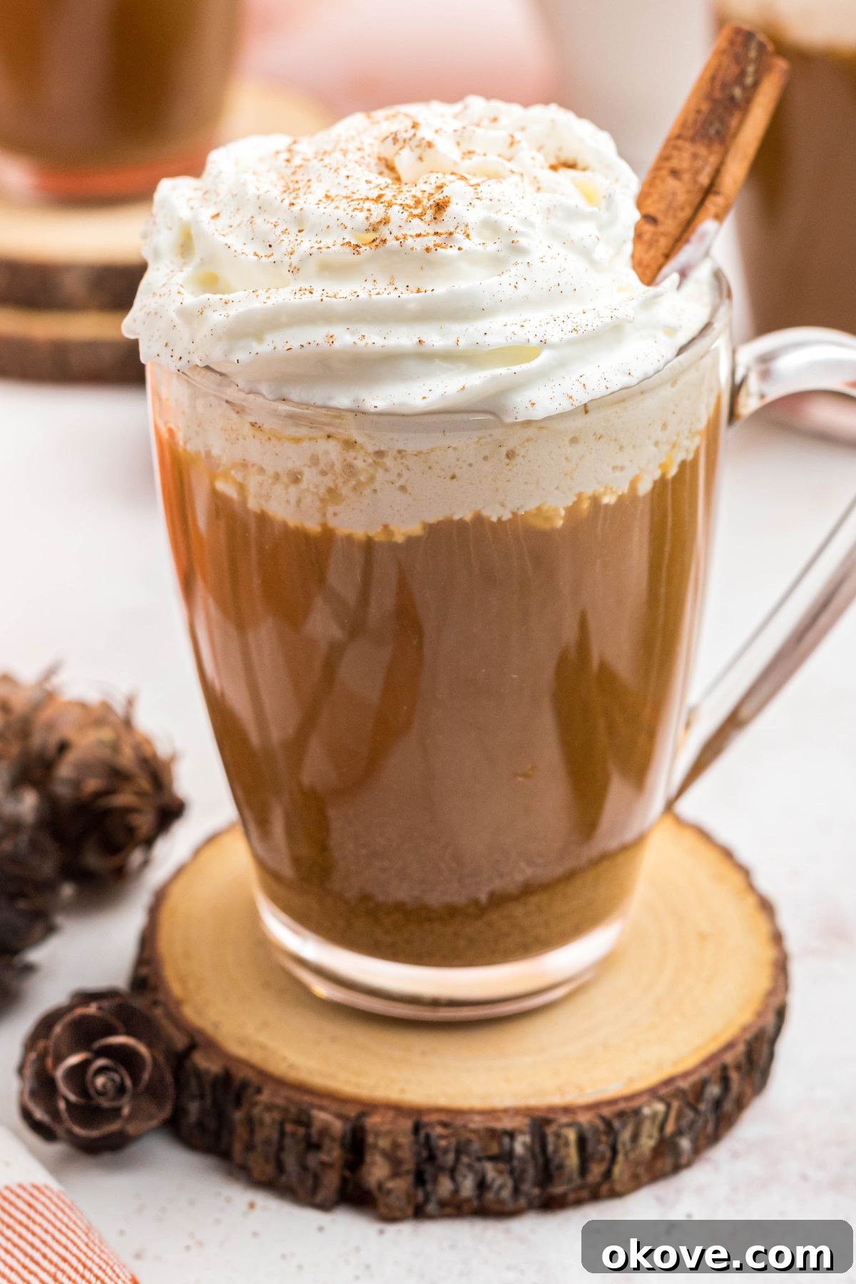 Cozy Pumpkin Spice Brew 8 Cup of pumpkin spice coffee topped with whipped cream and a cinnamon stick, presented beautifully on a marble board with a white pot.
