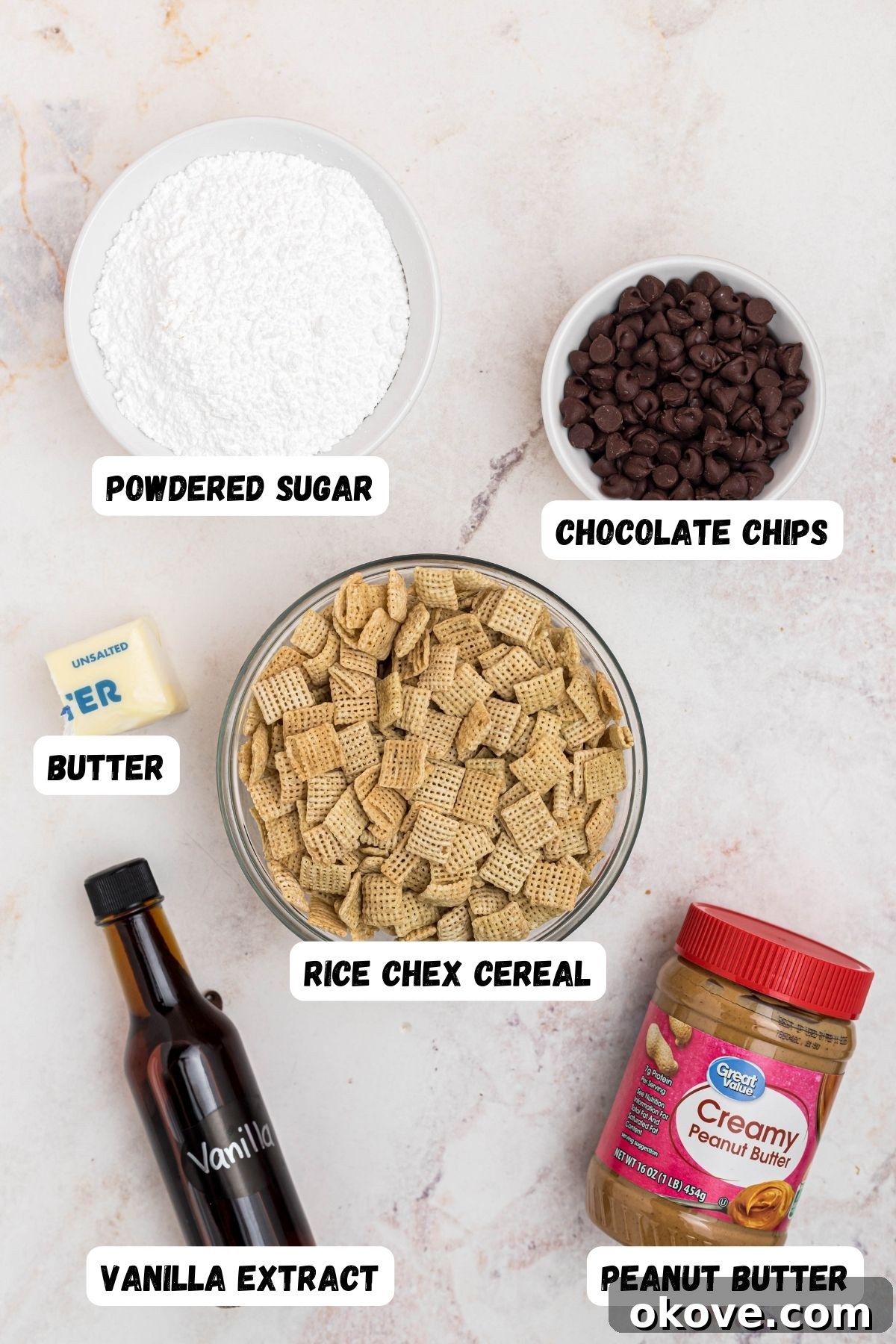 Ingredients needed to make puppy chow measure into small bowls and labeled on marble table. 
