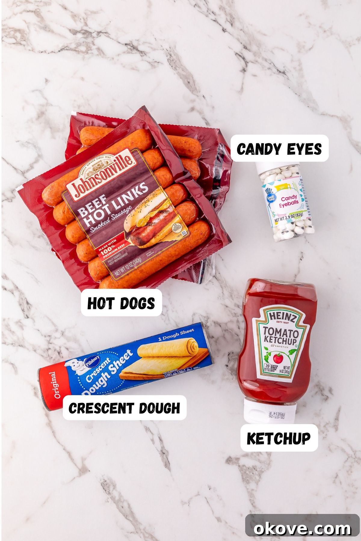 Mummy Hot Dogs 3 All the essential ingredients neatly arranged on a pristine marble surface, clearly labeled for easy identification, ready to be transformed into Mummy Hot Dogs.