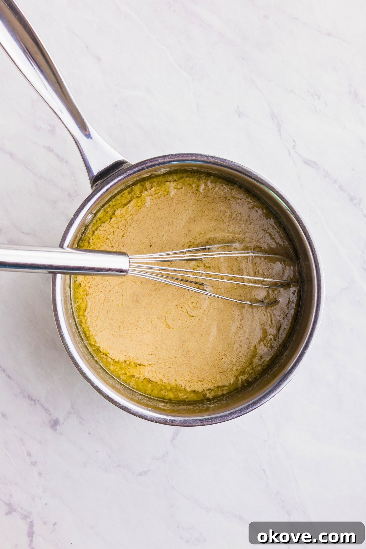 From Pan Drippings to Perfection 3 Melted butter in a sauce pan, being stirred by a whisk.